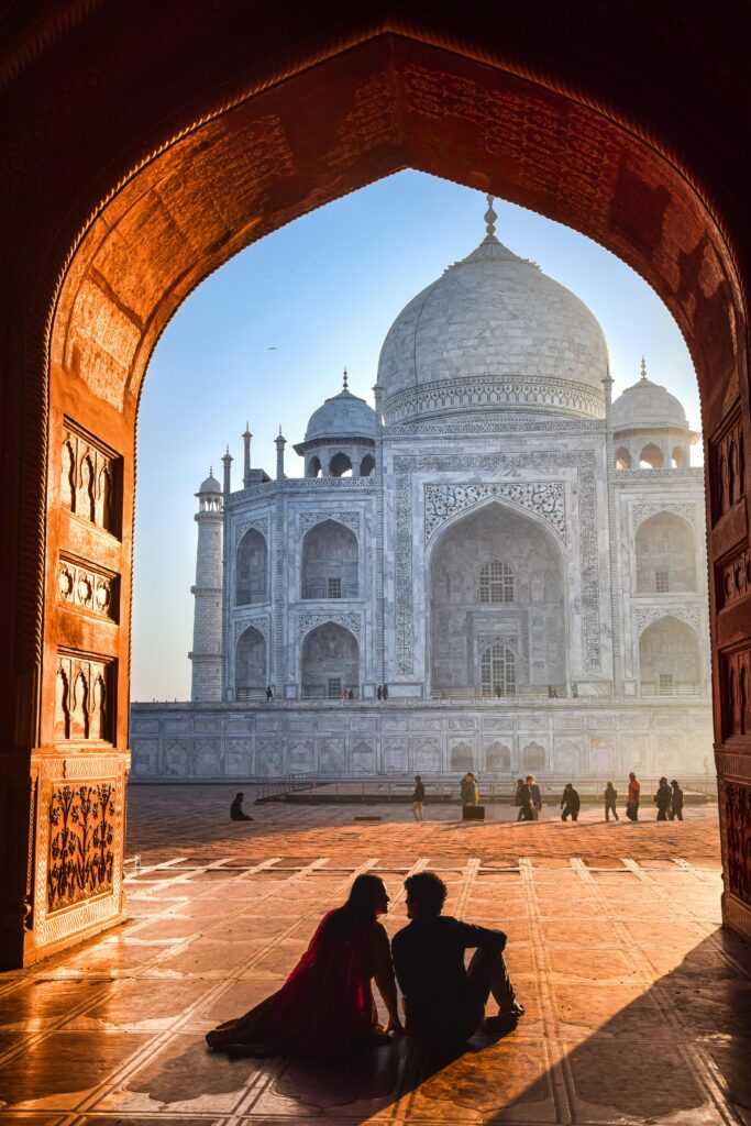 A couple sitting romantically at the iconic Taj Mahal in Agra, India.