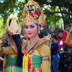 A group of dancers in colorful traditional attire at an outdoor cultural festival.